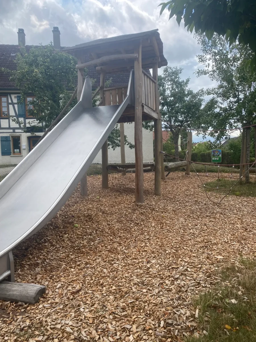 Spielplatz mit Rutsche und Hackschnitzeln als Fallschutzbelag